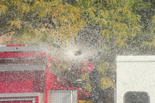 [Ogden Fireman Demonstrating Their Hose Blasts at Street Fair] style=